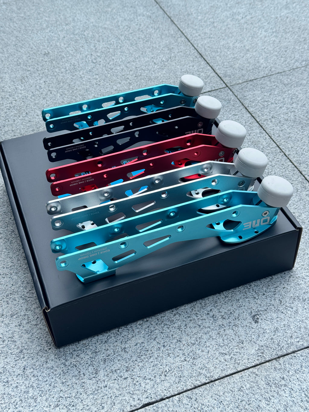Five ONE Blades EDGE inline figure skating frames in AETHER, GLACIER, OBSIDIAN and CRUCIBLE colorways displayed on the EDGE box
